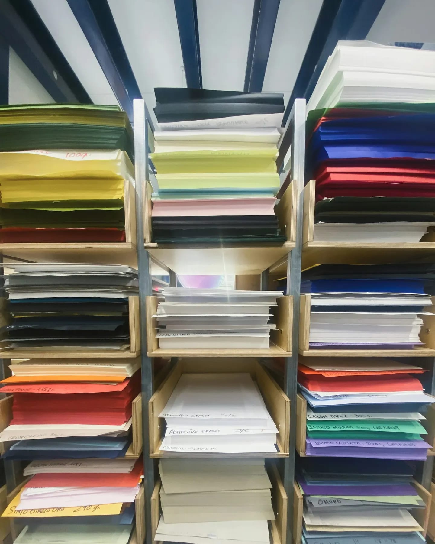 Rafturi cu hârtie colorată în atelierul de print